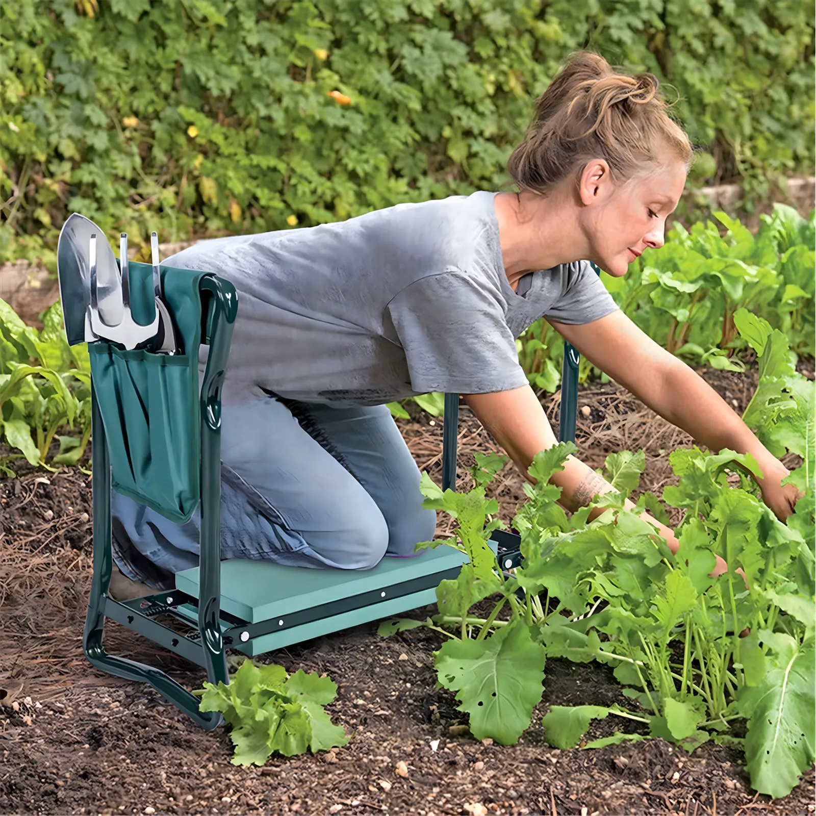 Kobieta klęcząca podczas zbierania warzyw w ogrodzie z klęcznikiem ogrodowym